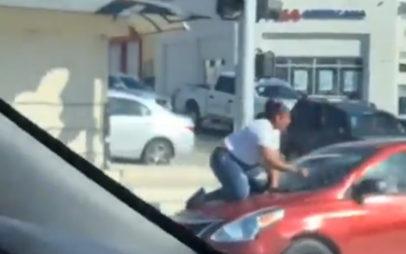 Mujer se trepa al cofre de un auto para que conductor no se escapara